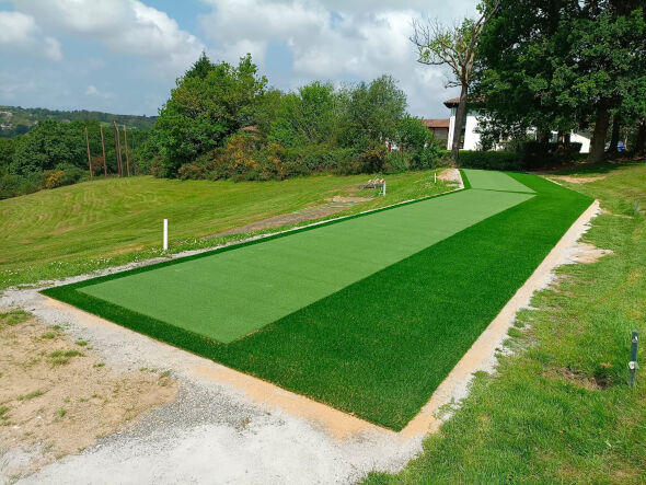 Huntsville Outdoor tee line consisting of one continuous green synthetic grass strip surrounded by trees